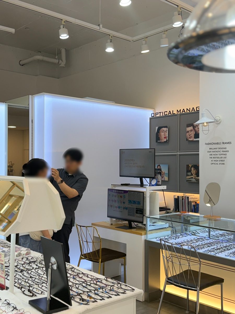 안경매니져 두정점 안경사가 고객과 마주 앉아 안경 착용감을 상담하는 모습